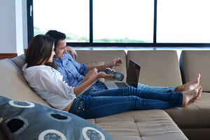 Couple on sofa with TV remote Couple on sofa with TV remote
