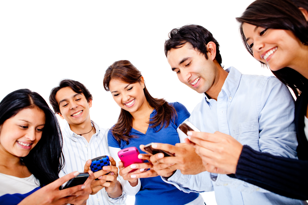 Group of young people texting on their cell phones isolated over white